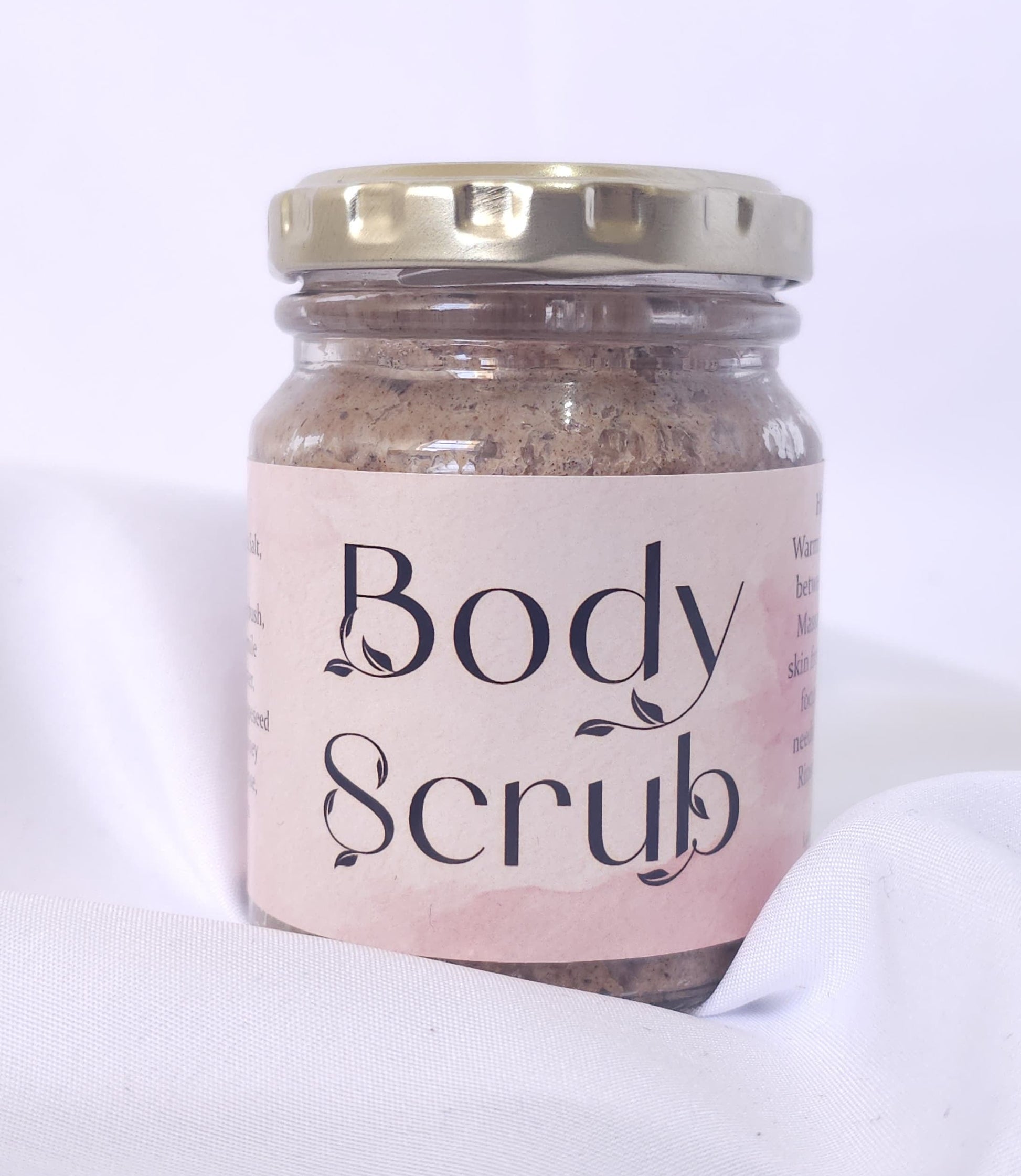 Jar of body scrub with a pink label on a white background